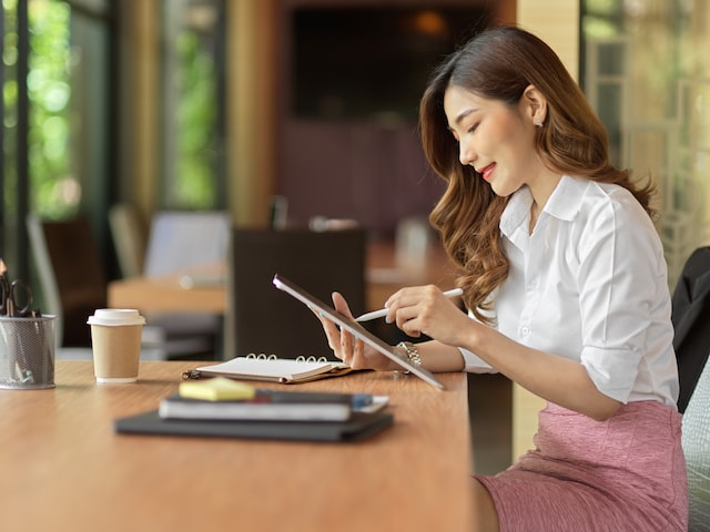 businesswoman checking stock from digital tablet