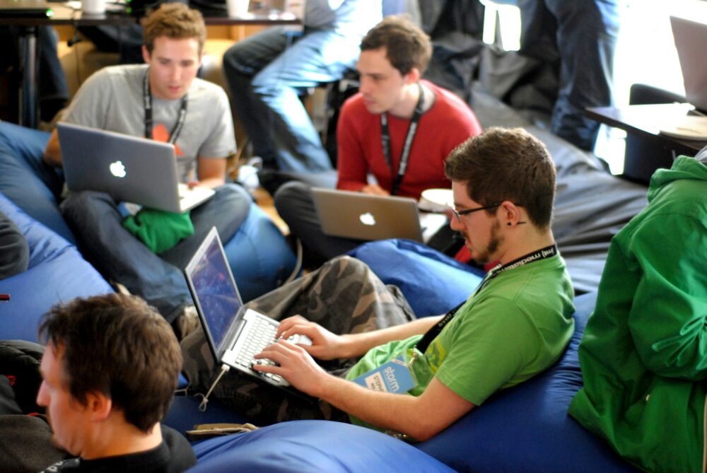 man-sitting-on-blue-bean-bag-usinglaptop